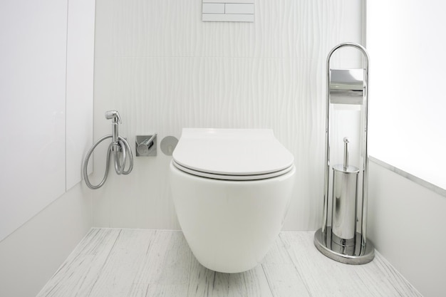 Toilet and detail of a corner shower bidet with wall mount shower attachment