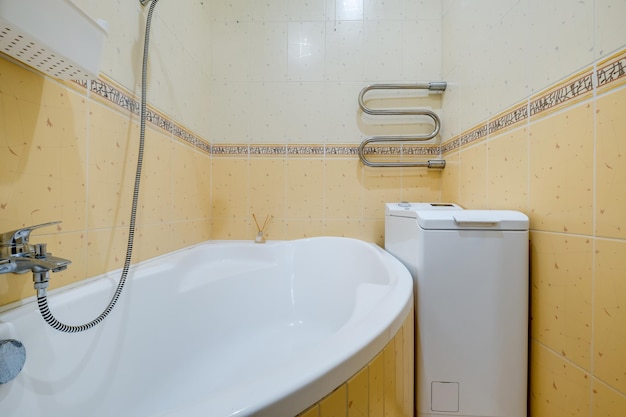 Toilet and detail of a corner shower cabin with wall mount shower attachment