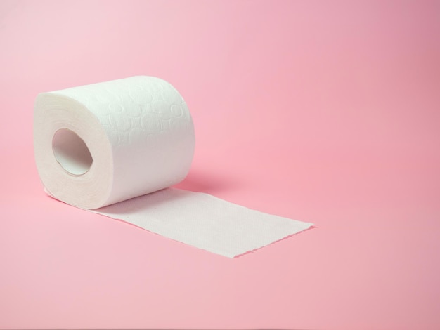 Toilet paper roll on pink background Space for text