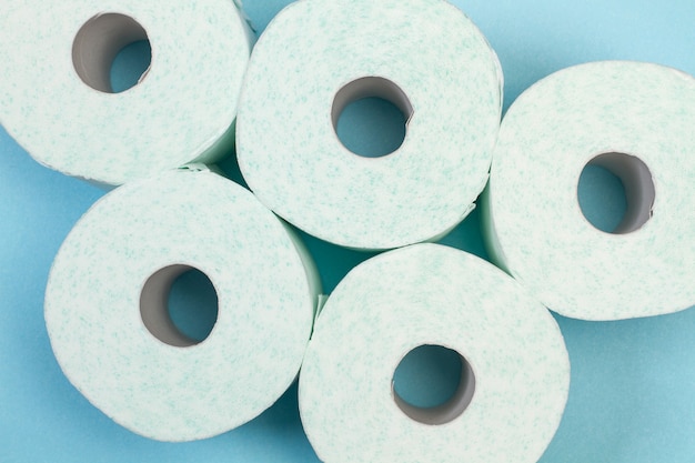 Toilet paper rolls on a light blue background in a top view