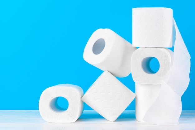 Toilet paper rolls stacked against blue background