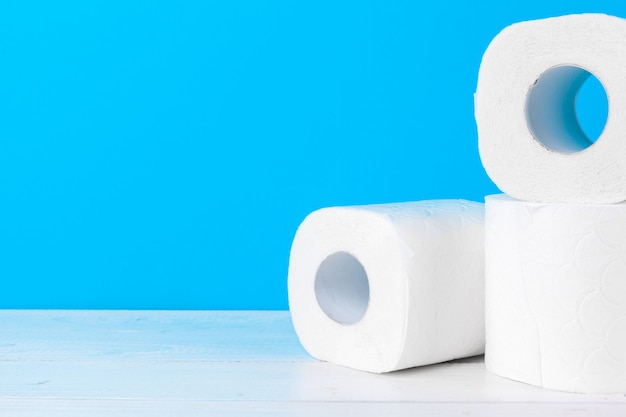 Toilet paper rolls stacked against blue