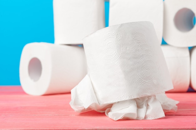 Toilet paper rolls stacked against blue