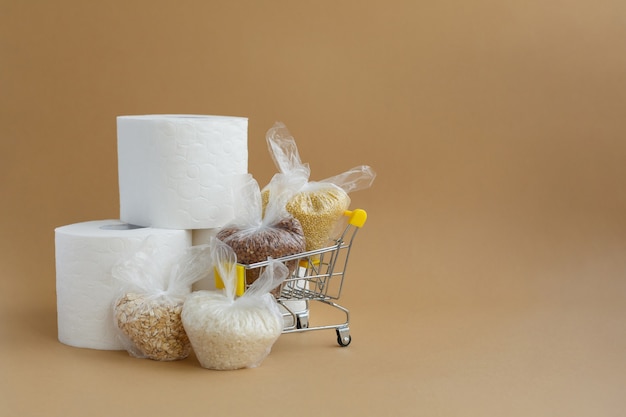 식료품 카트에 담긴 작은 비닐 봉지에 담긴 화장지 및 다양한 곡물 쌀과 오트밀 메밀과 기장