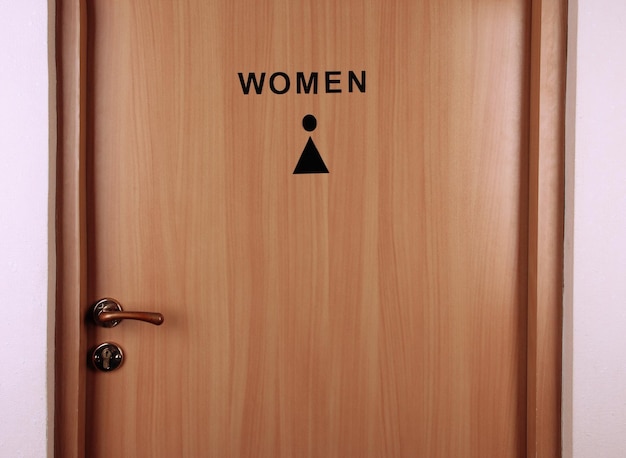 Toilet sign on wooden background