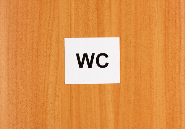 Toilet sign on wooden background