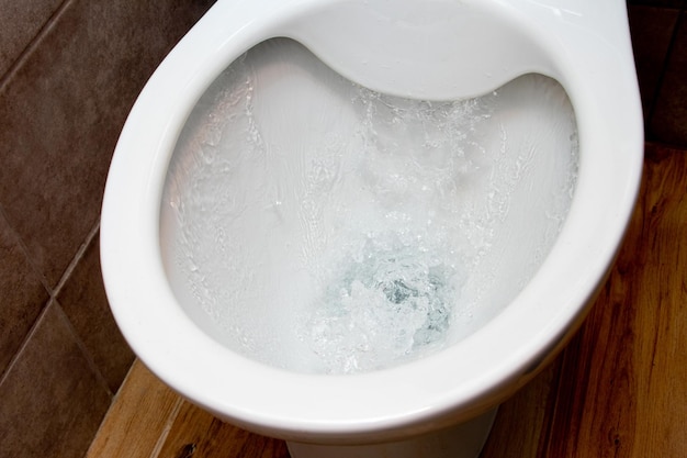 Toilet tijdens het spoelen van urine met water Een stroom water in de toiletpot