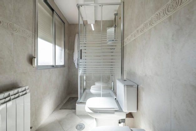 Toilet with glass shower stall white porcelain sink in vacation rental apartment
