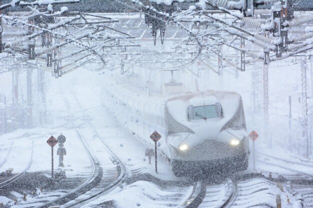 Photo tokaido shinkansen n700a passing through maibara station at snowy day