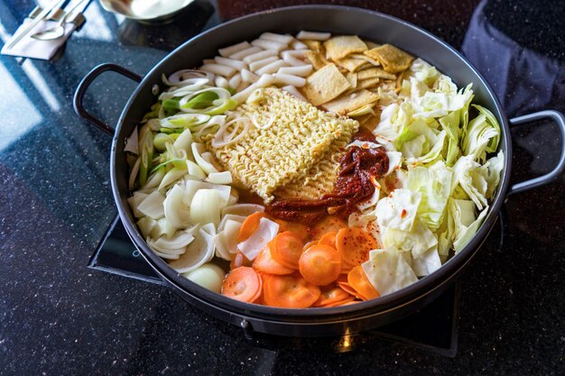 Tokboki Korean tranditional food hot and spicy rice cake combination and apply puff with cheese and vegetable on the black table