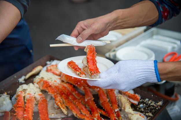 Tokyo, Japan Street in Tsukiji outer market in Ginza with closeup retail sample display of cooked red crab lobster legs white meat
