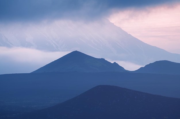 Vulcano tolbachik con nuvole all'alba. crateri vulcanici e campi di lava nera. penisola di kamchatka, russia.