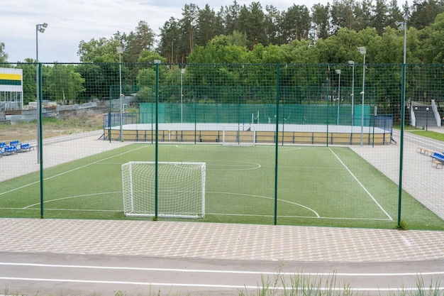 Tolyatti, Russia - July 25 2021: Green soccer field with blue seats. Sports stadium.