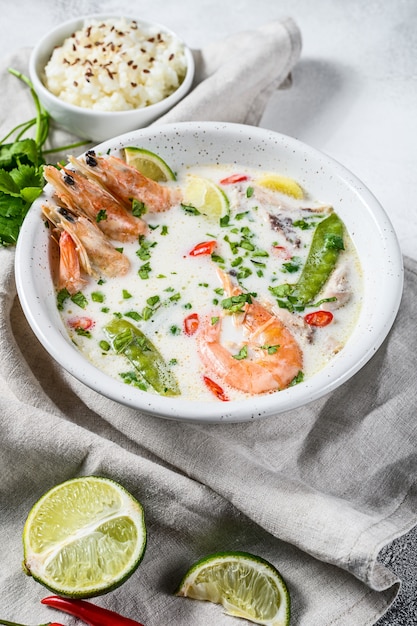 Tom Kha Gai. Pittige romige kokossoep met kip en garnalen. Thais eten. grijze achtergrond. Bovenaanzicht.