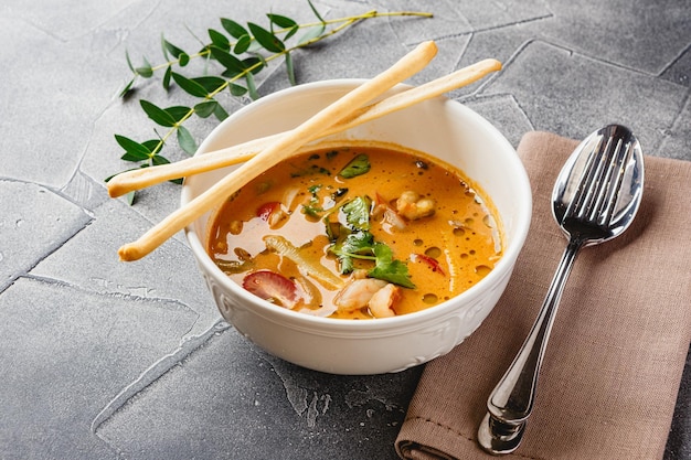 Tom yam kung pittige thaise soep met garnalen, zeevruchten, kokosmelk en chilipeper in kom