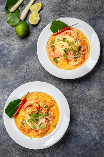 Photo tom yam kung prawn and lemon soup with mushrooms thai food in two white bowl top view