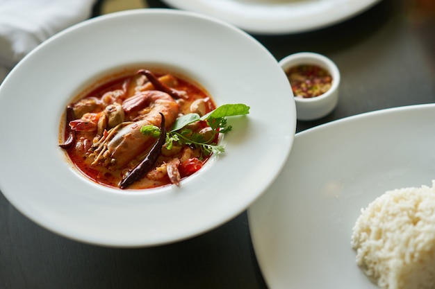 Tom yam kung con riso e salsa di pesce tuffo nel piatto famoso tradizionale tailandese