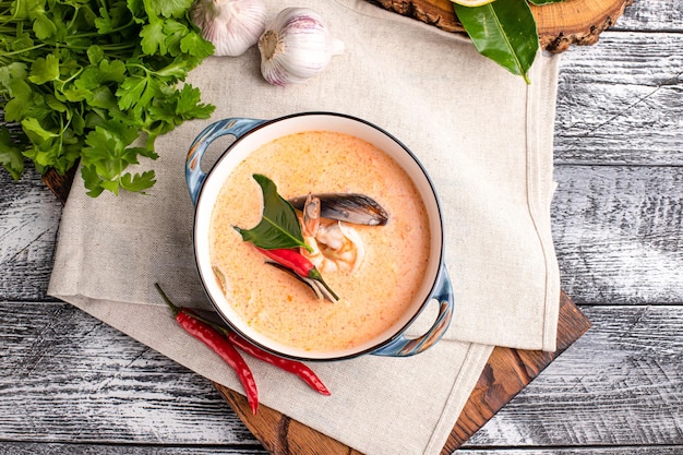 Tom yam tom yam soup with seafood on a wooden white\
background