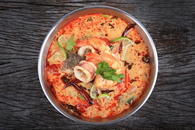 Tom yum kung of tom yum goong een pittige zure soep op houten tafelblad