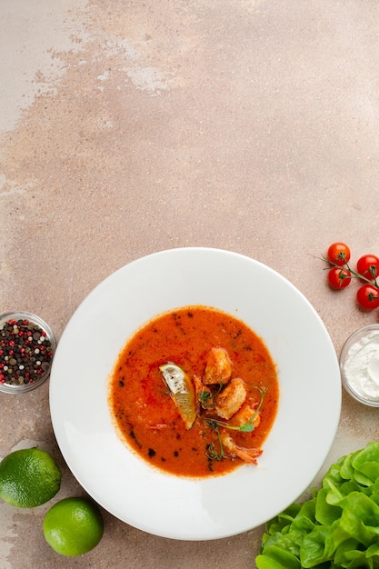 Tom yum in white plate on concrete background. Spicy Thai food with ingredients on table. Spicy Thai food top view