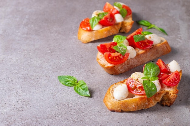 Tomaat, basilicum en kaas vers gemaakte caprese bruschetta. italiaanse tapas, antipasti met groenten, he