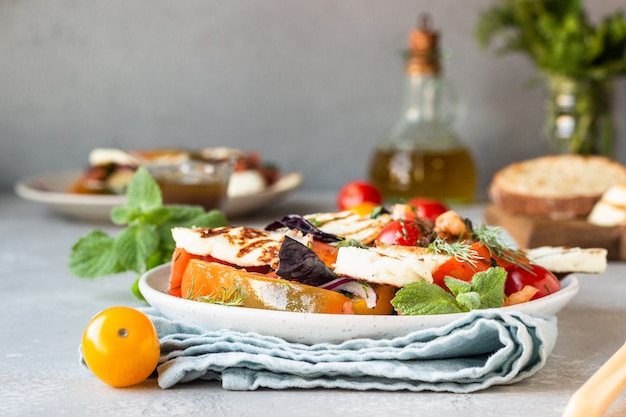 Tomaat, gebakken paprika en uiensalade met gegrilde kaas