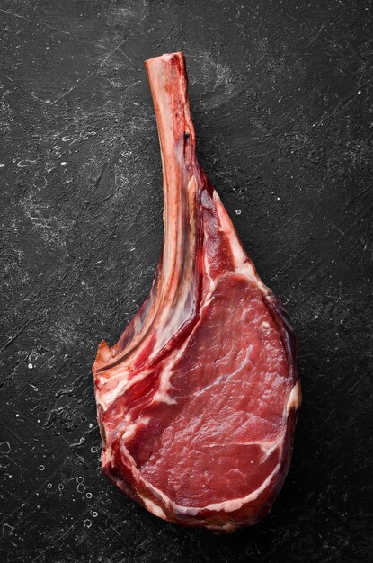 Tomahawk steak Rauwe biefstuk op een zwarte achtergrond Bovenaanzicht Free copy space