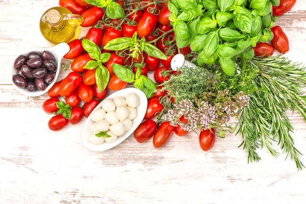 Tomaten, basilicumblaadjes, mozzarella en olijfolie. voedsel achtergrond. caprese salade ingrediënten