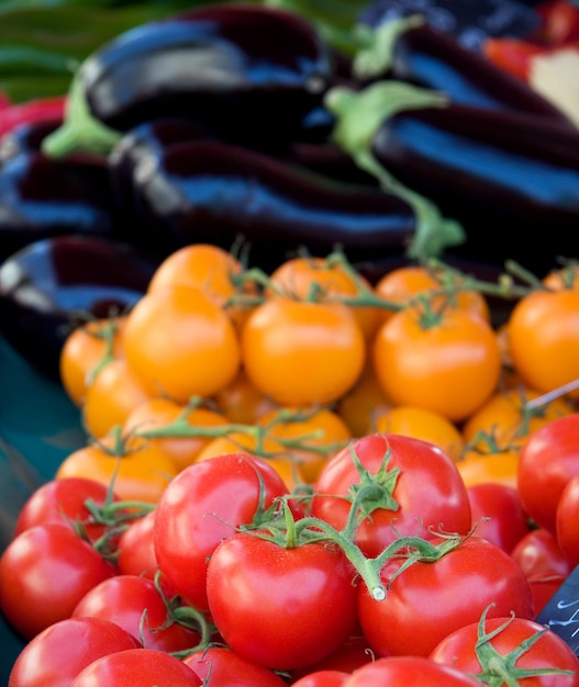 Tomaten en aubergines te koop op een markt Achtergrond van verse producten