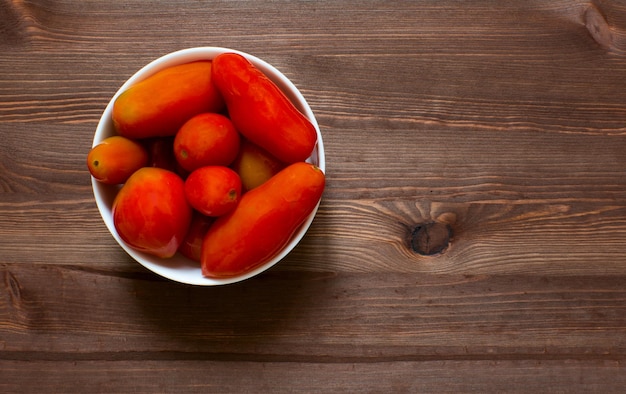 Tomaten in een bord op een houten ondergrond