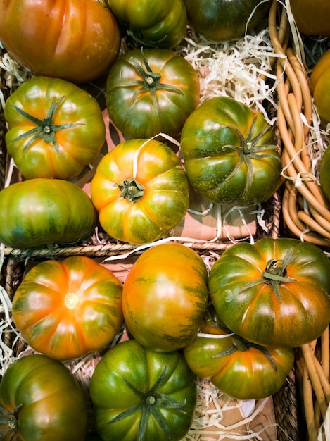 Tomaten in een rieten mand met houtkrullen in een bovenaanzicht