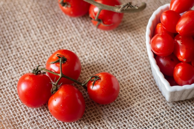 Tomaten in een witte kom en op een strotafel