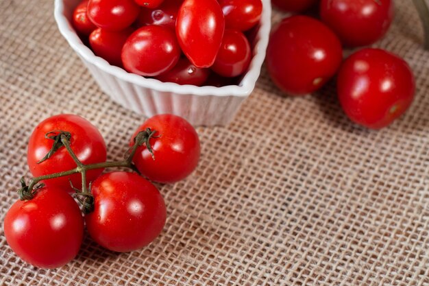 Tomaten in een witte kom en op een strotafel