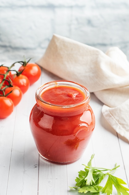 Tomaten in sap of tomatenpuree in een glazen pot