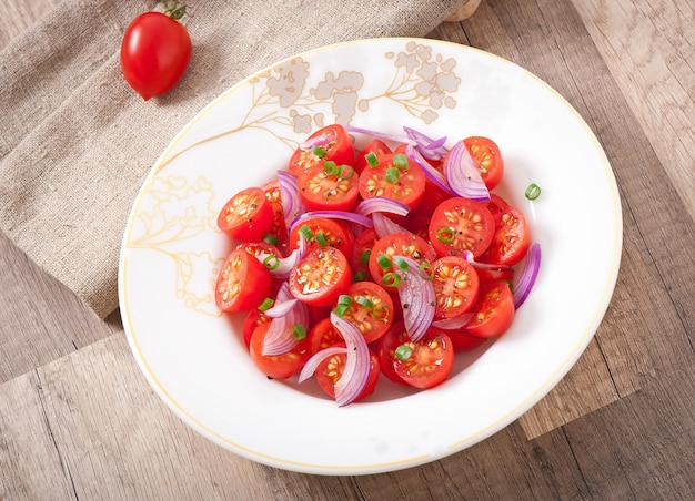 Foto tomaten-kersensalade met zwarte peper en ui