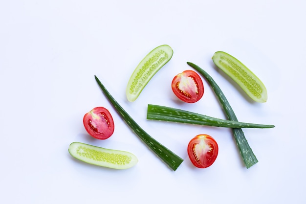 Tomaten, komkommers, aloë vera, natuurlijke ingrediënten voor zelfgemaakte huidverzorging op wit.