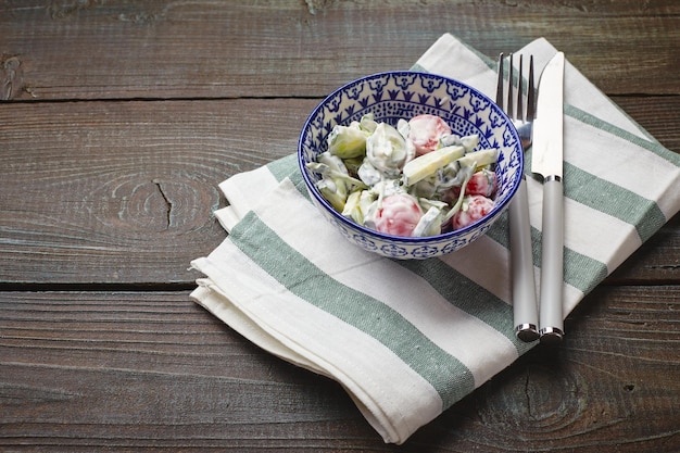 Tomaten-komkommersalade met zure room in een kleine kom