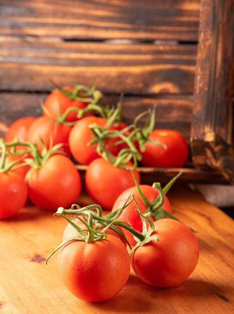 Tomaten mooie details van verse rode tomaten op takken over rustieke hout selectieve focus