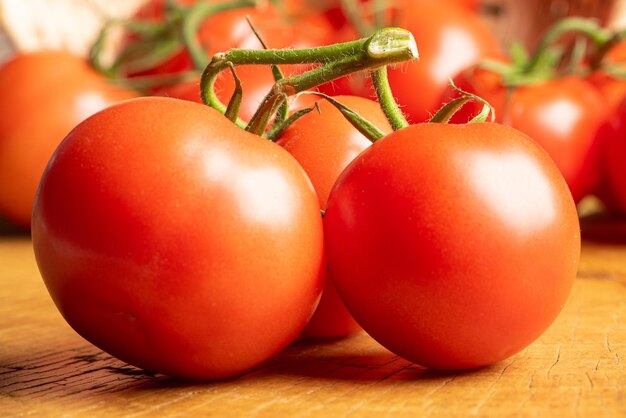 Tomaten, mooie tomaten gerangschikt over rustiek hout, selectieve aandacht.