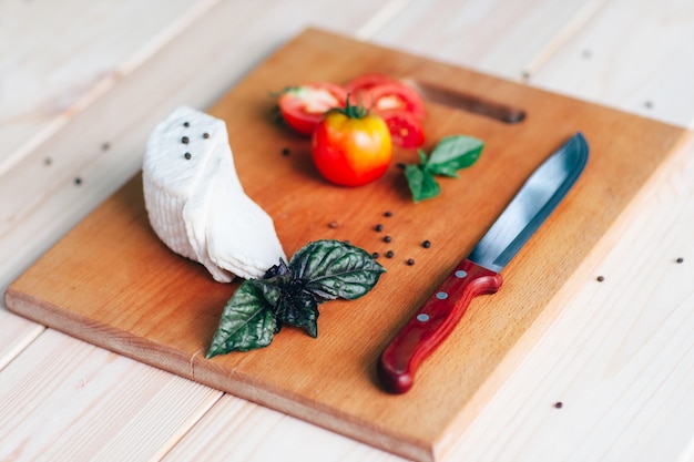 Tomatenkaasplakken met basilicummes op snijplank