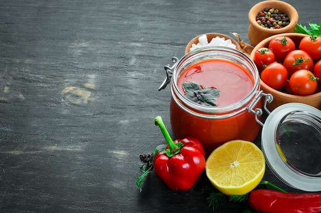 Tomatenpuree Ketchup met zelfgemaakte groenten Bovenaanzicht Op een zwarte achtergrond Vrije ruimte voor tekst