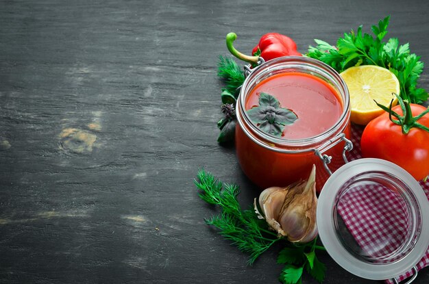 Tomatenpuree Ketchup met zelfgemaakte groenten Bovenaanzicht Op een zwarte achtergrond Vrije ruimte voor tekst