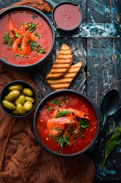 Tomatenroomsoep met garnalen in een zwarte kom Zeevruchtenmenu Bovenaanzicht Rustiek