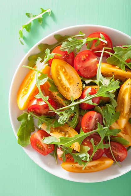 Tomatensalade met rucola op groene achtergrond