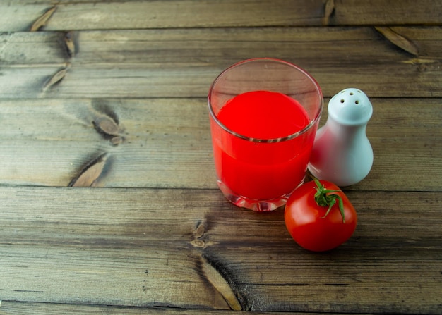 Tomatensap Zoutvaatje en tomaat op een houten tafel