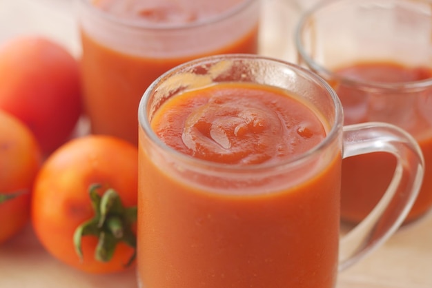 Tomatensaus in een potje met verse tomaat op tafel