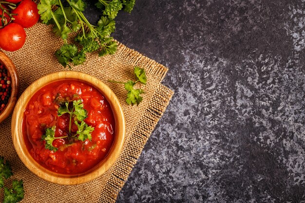 Tomatensaus met knoflook en peterselie in een houten kom