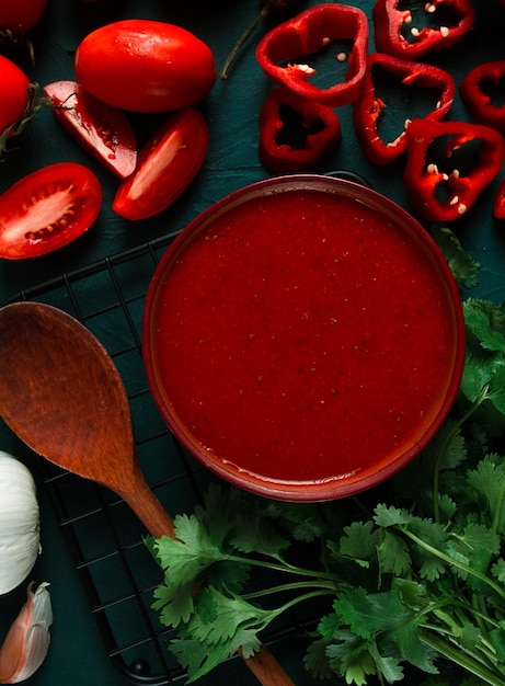 Tomatensaus, tomaten en paprika Georgische Satsebeli-saus met ingrediënten op een donkere achtergrond bovenaanzicht close-up geen mensen