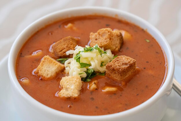 Tomatensoep met croutons kaas en verse peterselie close-up