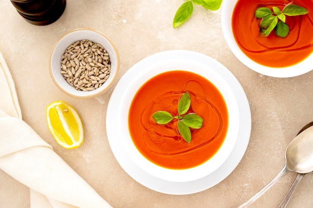 Tomatensoep met verse basilicum in witte kommen Geserveerd met zonnebloempitten Heldere achtergrond Bovenaanzicht kopieerruimte